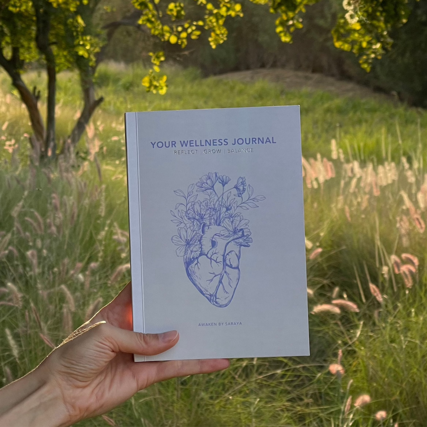The Awaken Wellness journal with a natural nature background
