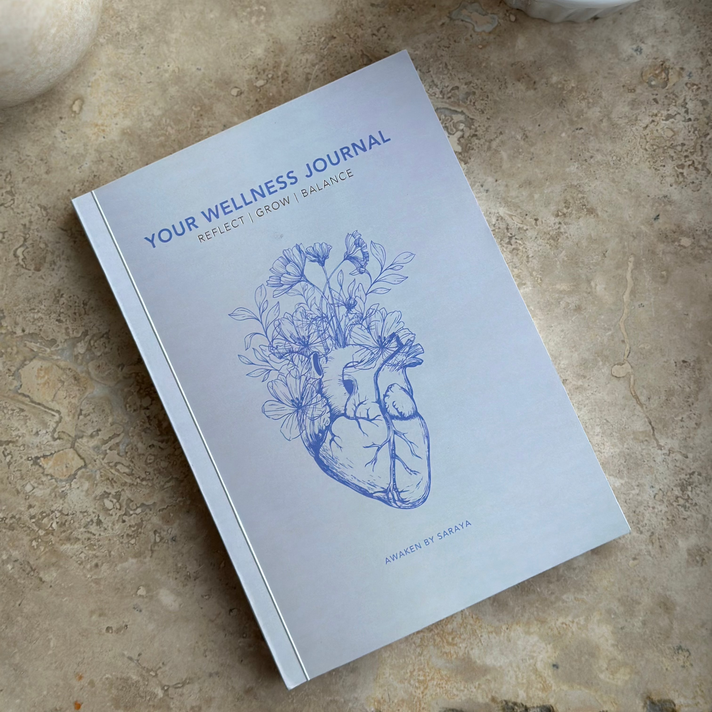 the Awaken Wellness journal with a matcha latte