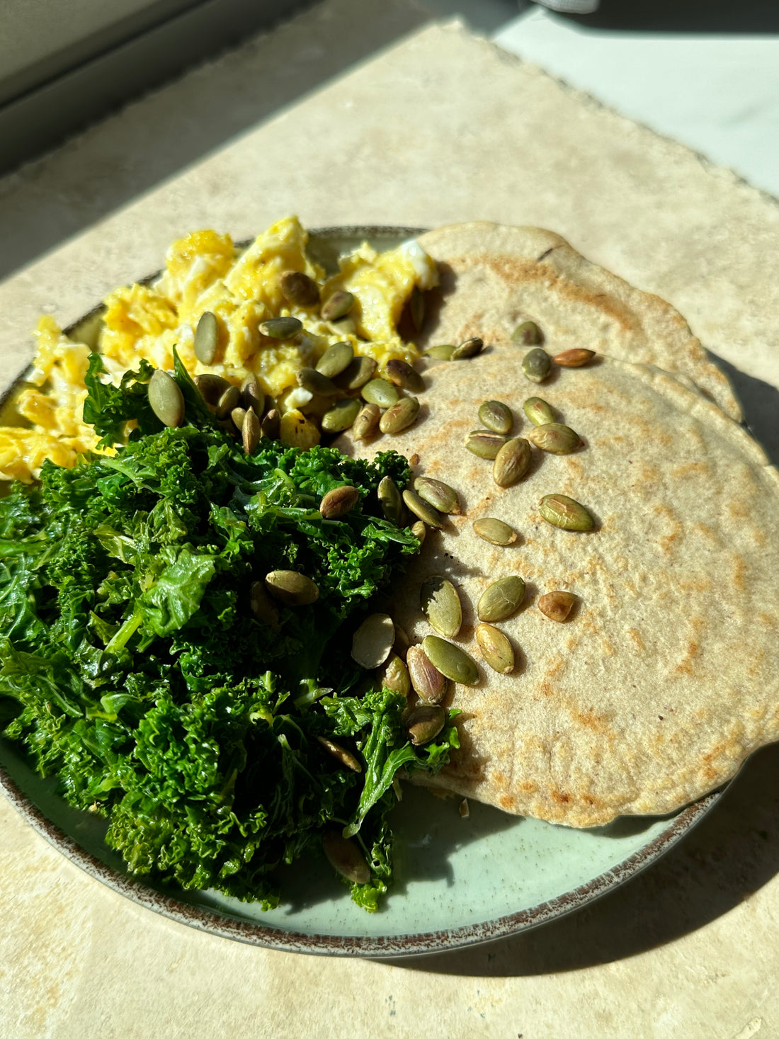 buckwheat pancakes with scrambled eggs and kale with pumpkin seeds