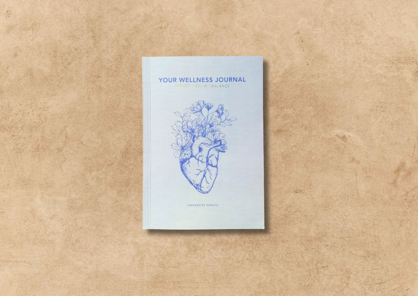 the awaken wellness journal on a neutral background