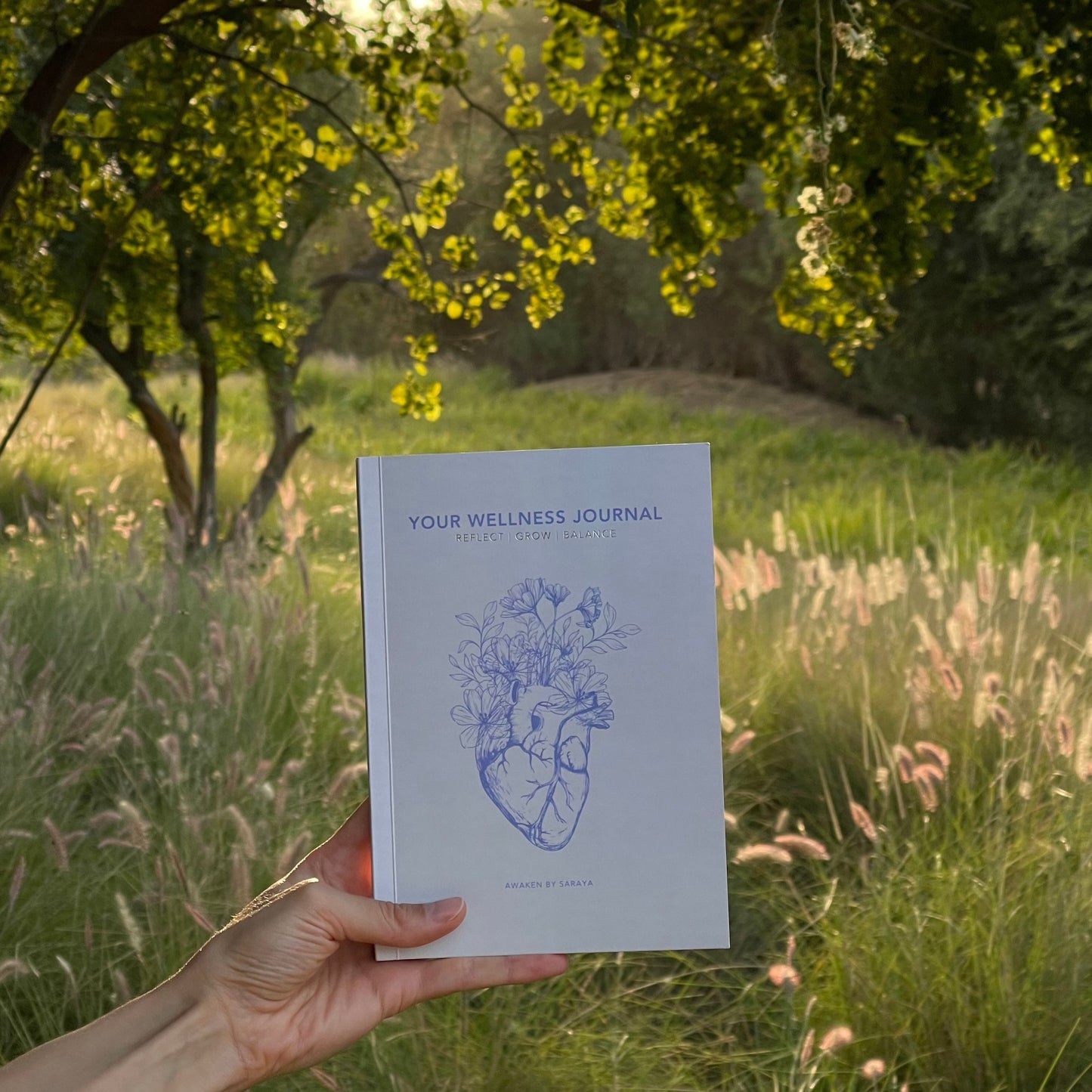 The Awaken Wellness journal with a natural nature background