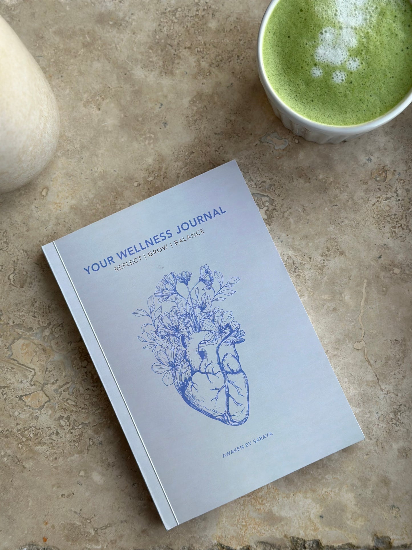 the Awaken Wellness journal with a matcha latte