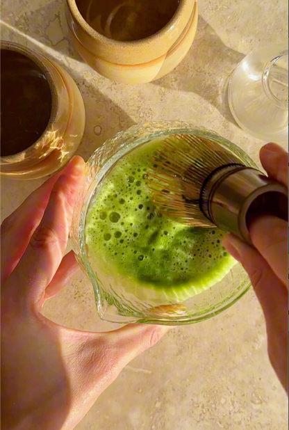 matcha preparation with bamboo chasen and glass matcha bowl. Preparation of the awaken organic ceremonial grade matcha 